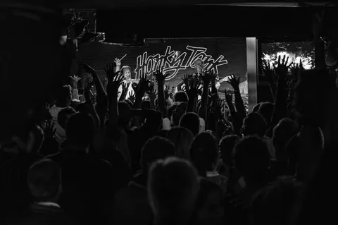 El público de espaldas frente al rótulo del Honky Tonk.