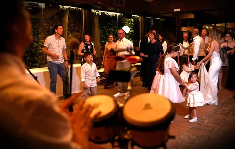 Las congas en primer plano y los invitados bailando al aire libre.