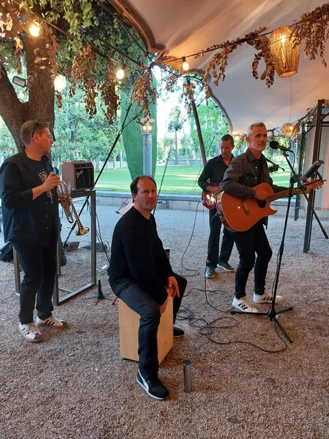 Últimos Clientes en formato acústico bajo un árbol, con trompeta, cajón y guitarras, en La Casa de Mónico.