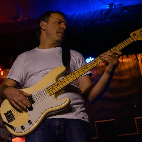 JB toca el bajo eléctrico en el escenario.