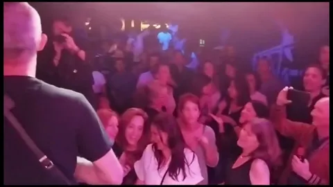 Público bailando pegado al escenario mientras la banda toca.